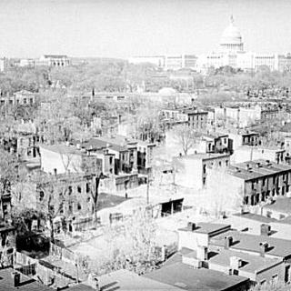 A view of Southwest from above. This is from pre-urban renewal circa 1939. Crowded streets full of buildings are in the foreground and the Capitol building is visible in the background. 